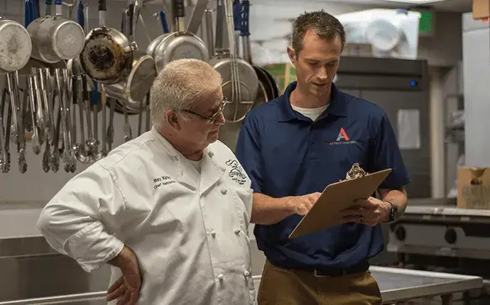 Pest professional and business owner review results of an inspection, highlighting the need for commercial pest control in Hickory, NC.